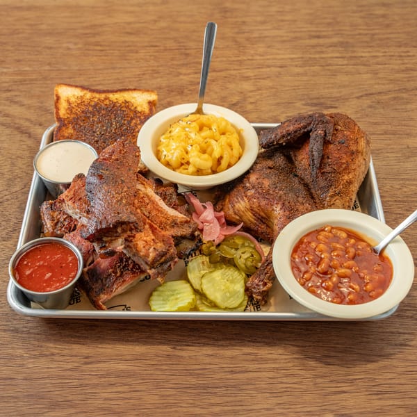 William's Barbecue platter with ribs, chicken, mac and cheese, baked beans, toast, and pickles.