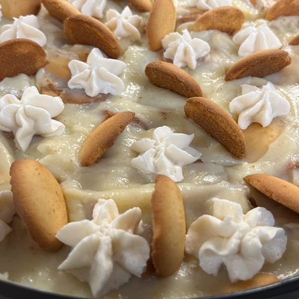 Creamy banana pudding with vanilla wafers and whipped cream dollops, a William's Barbecue dessert.