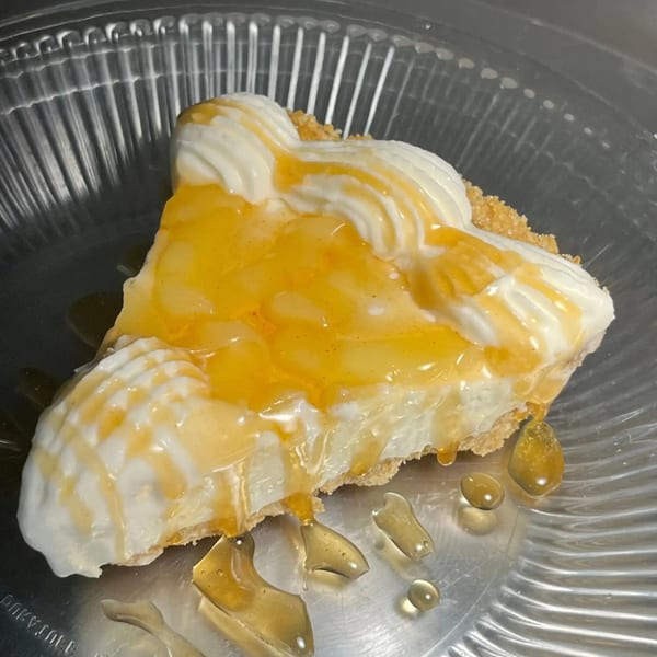 A slice of William's Barbecue banana pudding pie with whipped cream and honey drizzle.